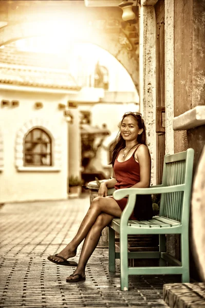 Asya güzel kadın oturup sakin yeşil ahşap sandalye — Stok fotoğraf