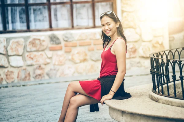 Asiatique femme assise sur le banc de pierre en ville — Photo