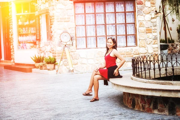 Asian kobieta siedzi na ławce kamień w mieście — Zdjęcie stockowe