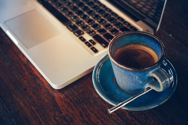 Tasse à café chaude et ordinateur portable sur table en bois — Photo