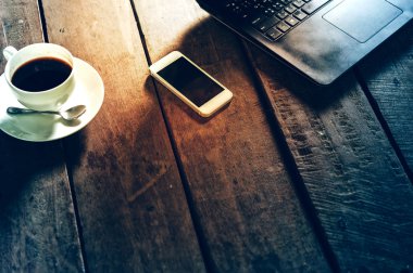 Kahve Kupası laptop ve ahşap masa akıllı telefon