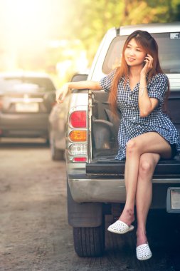 Cep telefonu kullanan güzel genç kadın oturup araba