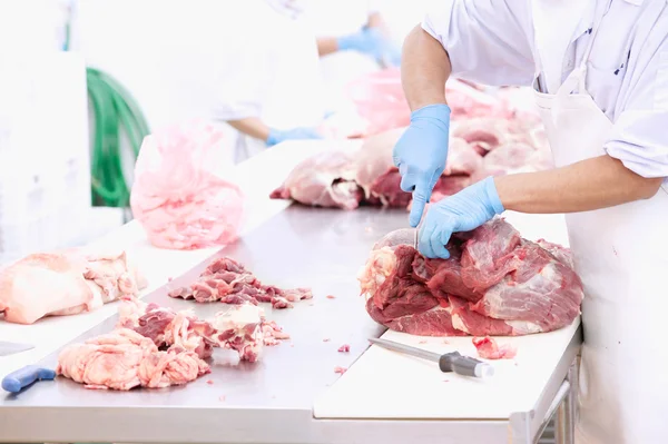 Açougueiro cortando carne na mesa — Fotografia de Stock
