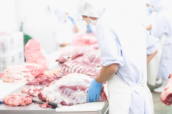 Açougueiro que corta carne de porco fresca — Fotografia de Stock
