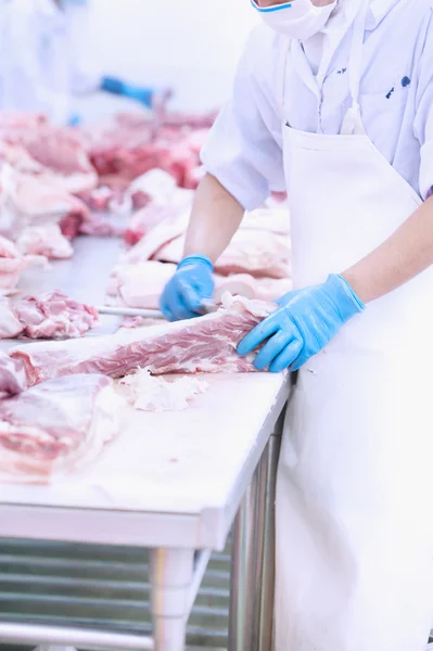 Butcher cutting meat on the table — Stock Photo, Image
