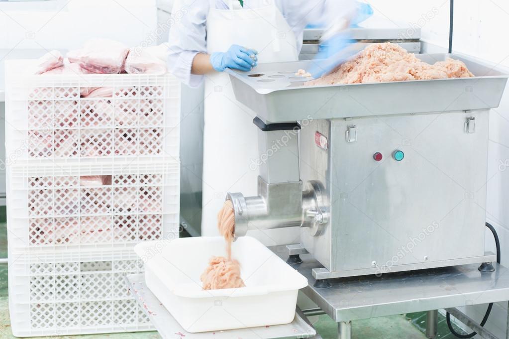 worker mincing meat at  butcher shop 