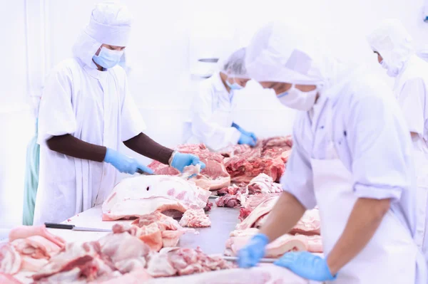 Açougueiro cortando carne na mesa — Fotografia de Stock