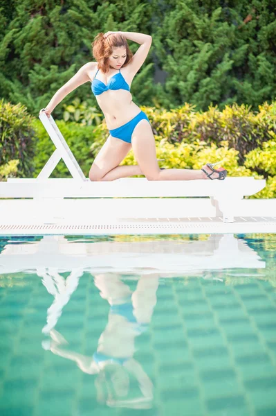Biquíni mulher asiática no banho de sol longue na piscina — Fotografia de Stock