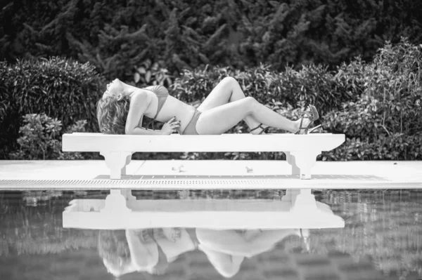 black and white bikini asia woman on sunbath longue by the pool