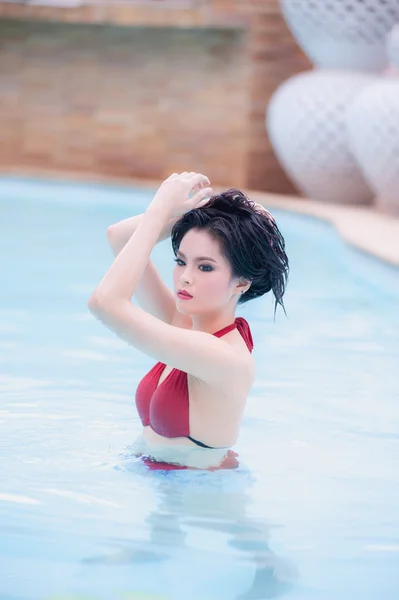 Ásia sexy jovem mulher de pé na água na piscina — Fotografia de Stock