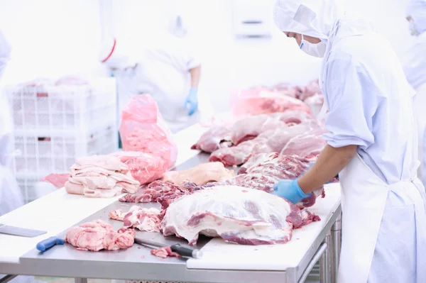 Açougueiro cortando carne na mesa — Fotografia de Stock