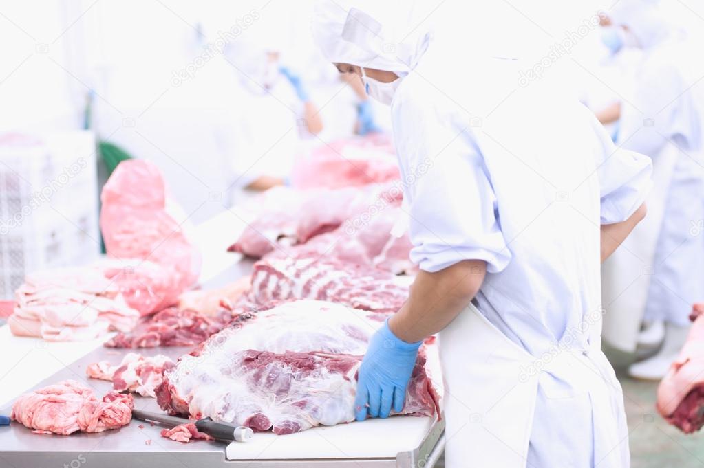 butcher cutting meat on the table 
