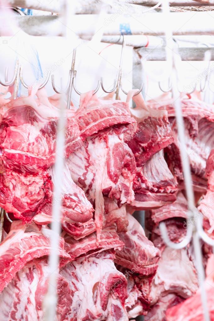 close up of pork hanging in cold room 