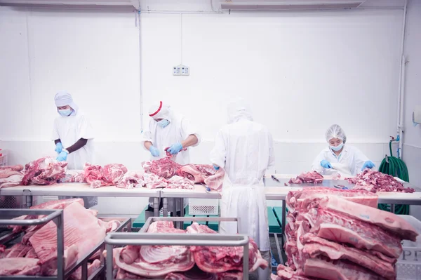 Açougueiro que corta carne de porco fresca — Fotografia de Stock