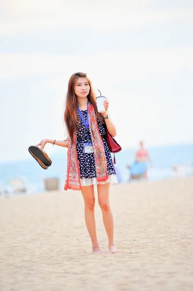 Asia beautiful woman on the beach, hold iced coffee and shoes — Stock Photo, Image