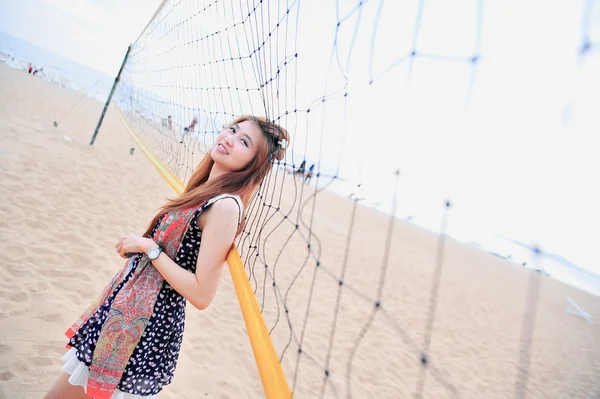Porträtt av Asien ung kvinna nära volleyboll netto på stranden — Stockfoto