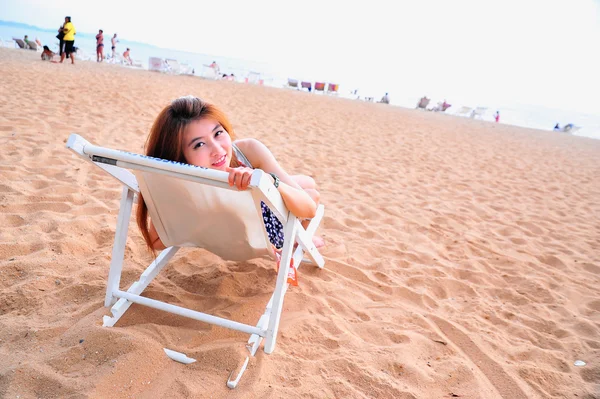 Asia young lady relaxing in chair on beach — Stock Photo, Image