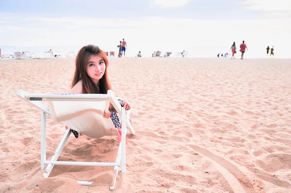 Asya genç bayan plaj sandalye rahatlatıcı — Stok fotoğraf