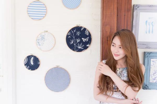 美丽的亚洲年轻女人站在咖啡馆的墙上 — 图库照片
