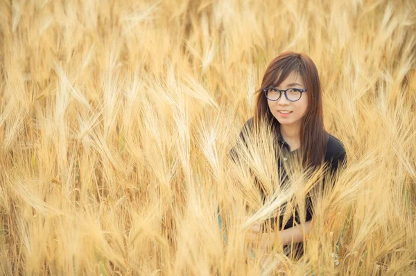 Árpa mező egy szép szemüveg nő portréja — Stock Fotó