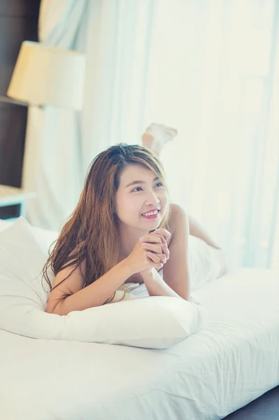 美丽的年轻女子，穿着白色浴袍在家里的卧室里 — 图库照片