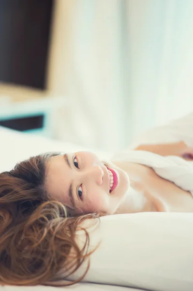 Mooie jonge vrouw in witte badjas in slaapkamer thuis — Stockfoto