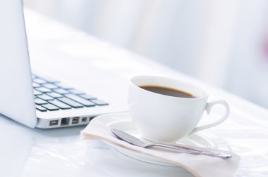 İş için kahve fincanı ve laptop. 