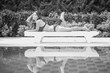 Bikini Asya kadın havuz kenarında güneşlenmek longue üzerinde 