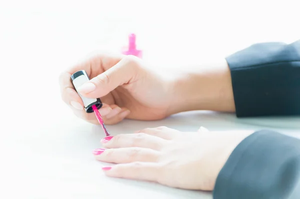 Woman applying pink nail polish on hand — Stock Photo, Image