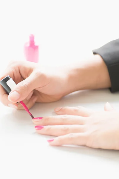 Woman applying pink nail polish on hand — Stock Photo, Image