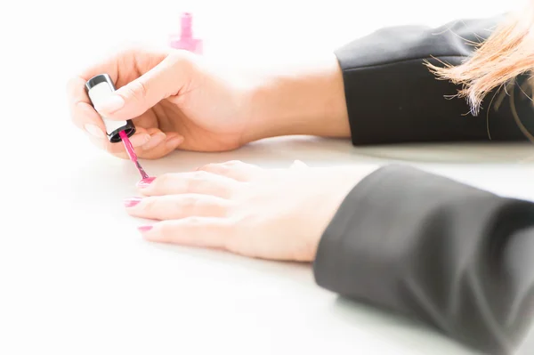 Woman applying pink nail polish on hand — Stock Photo, Image