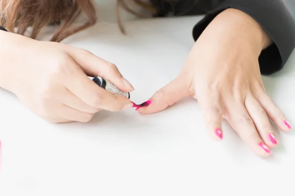 Woman applying pink nail polish on hand — Stock Photo, Image