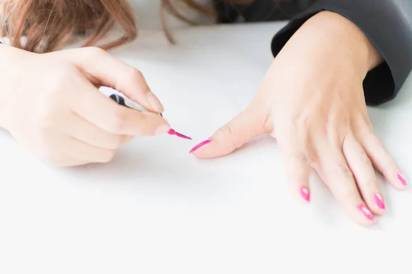 Woman applying pink nail polish on hand — Stock Photo, Image