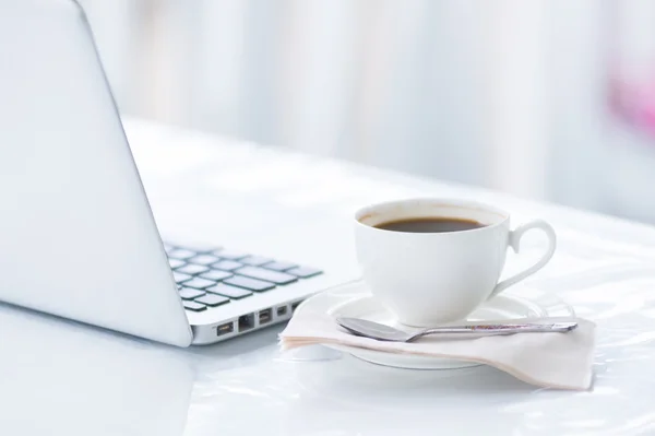 コーヒーカップとビジネス用ノートパソコン — ストック写真