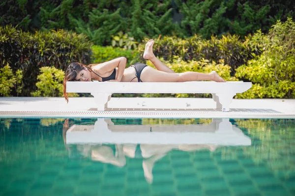 Bikini asia mujer en sunbath longue junto a la piscina — Foto de Stock