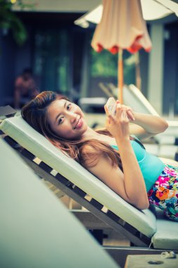 güzel kadın kaka Yüzme yakınındaki tembel bir akıllı telefon kullanma