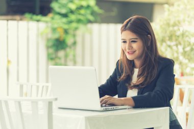  Dizüstü bilgisayar ile kafede oturan Asya genç iş kadını 