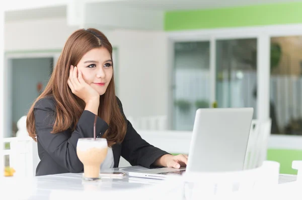 Asia joven mujer de negocios sentada en un café con café helado y — Foto de Stock