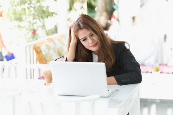 Ásia jovem mulher de negócios sentado em um café com laptop — Fotografia de Stock