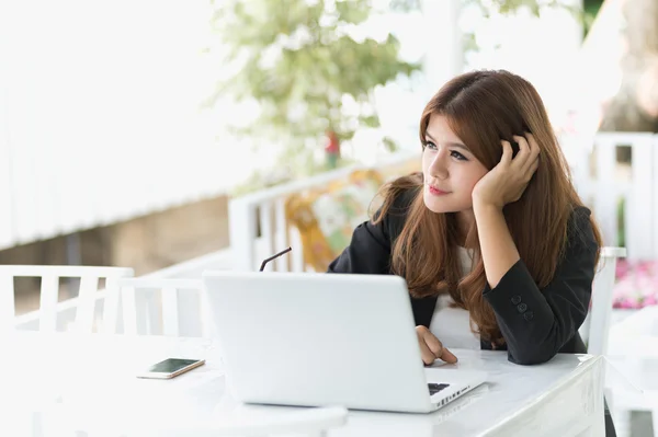 Asia joven mujer de negocios sentada en un café con portátil — Foto de Stock