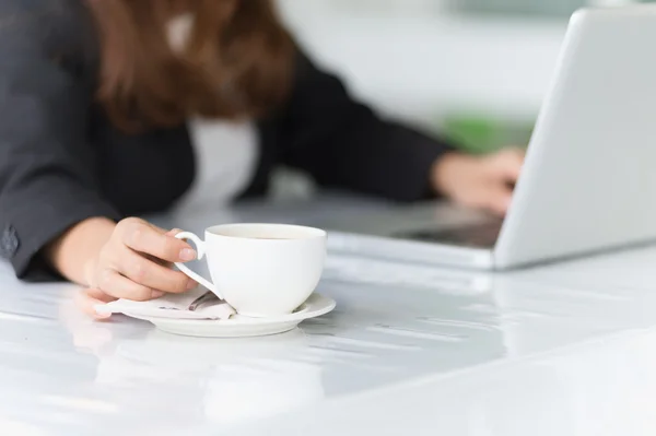 Asia young business woman sitting in cafe with laptop and hot co