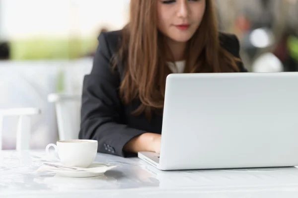 Asia joven mujer de negocios sentado en una cafetería con ordenador portátil y coff — Foto de Stock