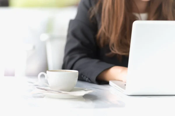 Asia joven mujer de negocios sentado en una cafetería con ordenador portátil y coff — Foto de Stock