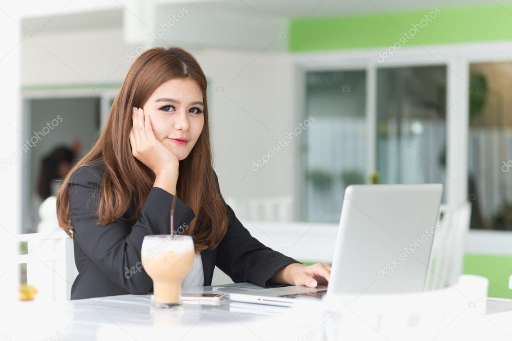 Asia young business woman sitting in a cafe with iced coffee and