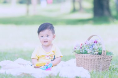 Asya bebek çocuk parkta yeşil çimenlerin üzerinde 