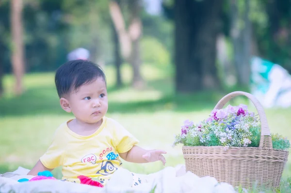 เด็กชายเอเชียบนหญ้าสีเขียวในสวนสาธารณะ — ภาพถ่ายสต็อก