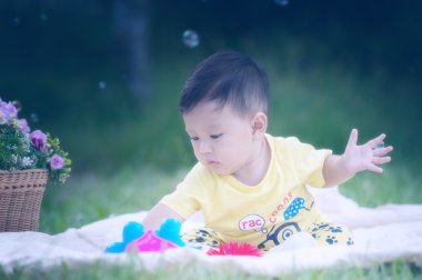 Asya bebek çocuk parkta yeşil çimenlerin üzerinde 