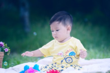 Asya bebek çocuk parkta yeşil çimenlerin üzerinde 