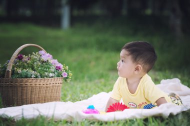 Sabun köpüğü ile yeşil çimenlerin üzerinde oturan erkek Asya bebek 