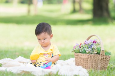 Asya bebek çocuk parkta yeşil çimenlerin üzerinde 